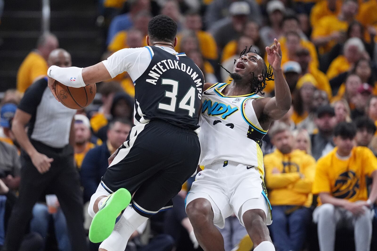 Milwaukee Bucks' Giannis Antetokounmpo (34) collides with Indiana Pacers' Aaron Nesmith during the first half of a first-round NBA basketball playoff game, Saturday, April 19, 2025, in Indianapolis. (AP Photo/Michael Conroy)