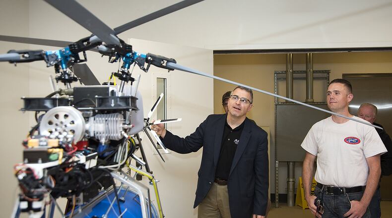Senior Airman Rob Dome, right, a member of Team Eglin, shows Maj. Gen. William T. Cooley, Air Force Research Laboratory commander, a remote-controlled helicopter March 2, he designed and built for his team to use in the AFRL Commanders Challenge at Redstone Arsenal, Huntsville, Ala. Team Eglin, which won this year’s challenge, designed and built the helicopter and a supply canister that uses the principle of auto-rotation to deliver supplies to remote, forward-deployed troops. (U.S. Air Force photo/R.J. Oriez)