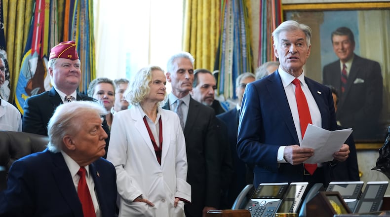 President Donald Trump listens as Centers for Medicare & Medicaid Services administrator Dr. Mehmet Oz speaks during an executive order signing in the Oval Office of the White House, Thursday, Dec. 18, 2025, in Washington. (AP Photo/Evan Vucci)