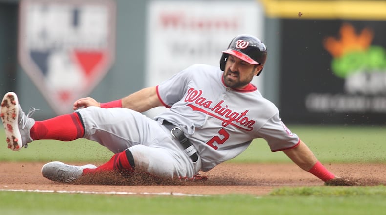 The Nationals’ Adam Eaton slides into third base against the Reds on Opening Day on Friday, March 30, 2018, at Great American Ball Park in Cincinnati. David Jablonski/Staff
