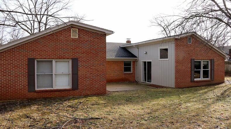 Two bonus rooms create a courtyard patio setting that looks out over a semi-wooded side yard.