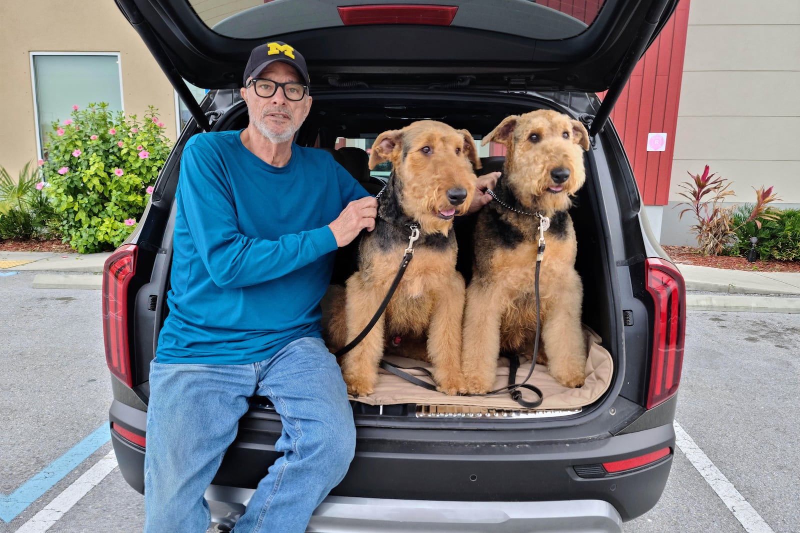 In this undated photo provided by Maida Candler, Bill Cantle poses with his Airedales, Emmett and Molly, in Clearwater, Fla.. (Maida Candler via AP)