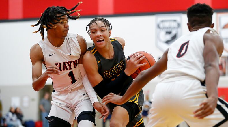 Springfield High School sophomore Aaron Scott drives through Wayne's Lawrent Rice (left) and RJ Mukes (right) during a game earlier this season. CONTRIBUTED PHOTO BY MICHAEL COOPER