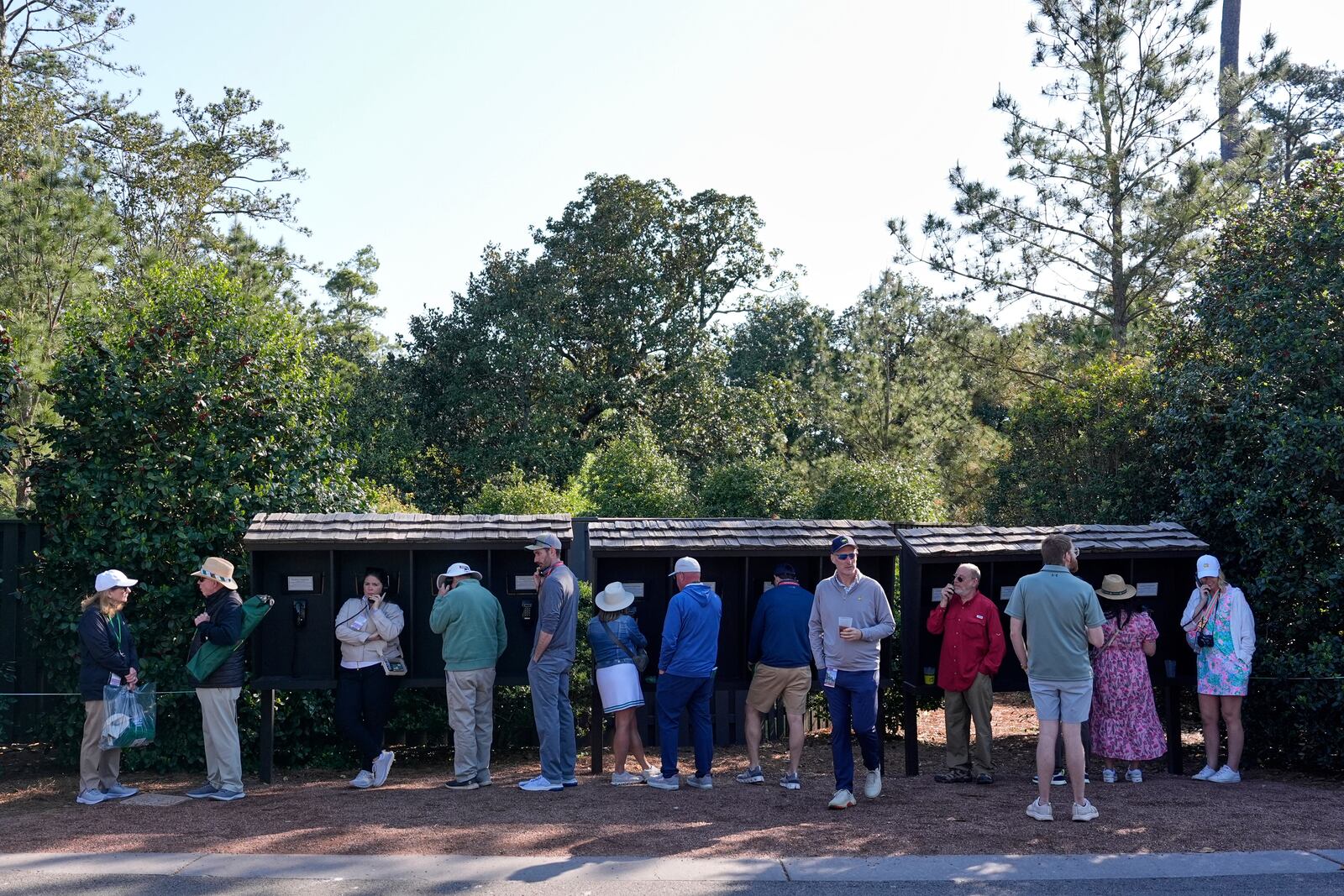 Patrons line up to use courtesy phones during a practice around at the Masters golf tournament, Wednesday, April 9, 2025, in Augusta, Ga. (AP Photo/Ashley Landis)