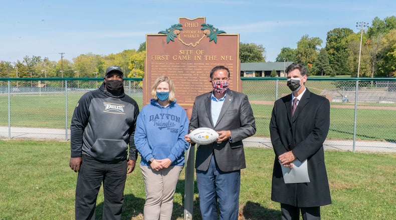 (Left to right) Ohio NFL legend Keith Byars, Mayor Nan Whaley, Columbus Mayor Andy Ginther and CEO of Dayton History Brady Kress gathered at Triangle Park Saturday to commemorate the centennial anniversary of the first NFL game. On Oct. 3, 1920, the Dayton Triangles beat the Columbus Panhandles 14-0.