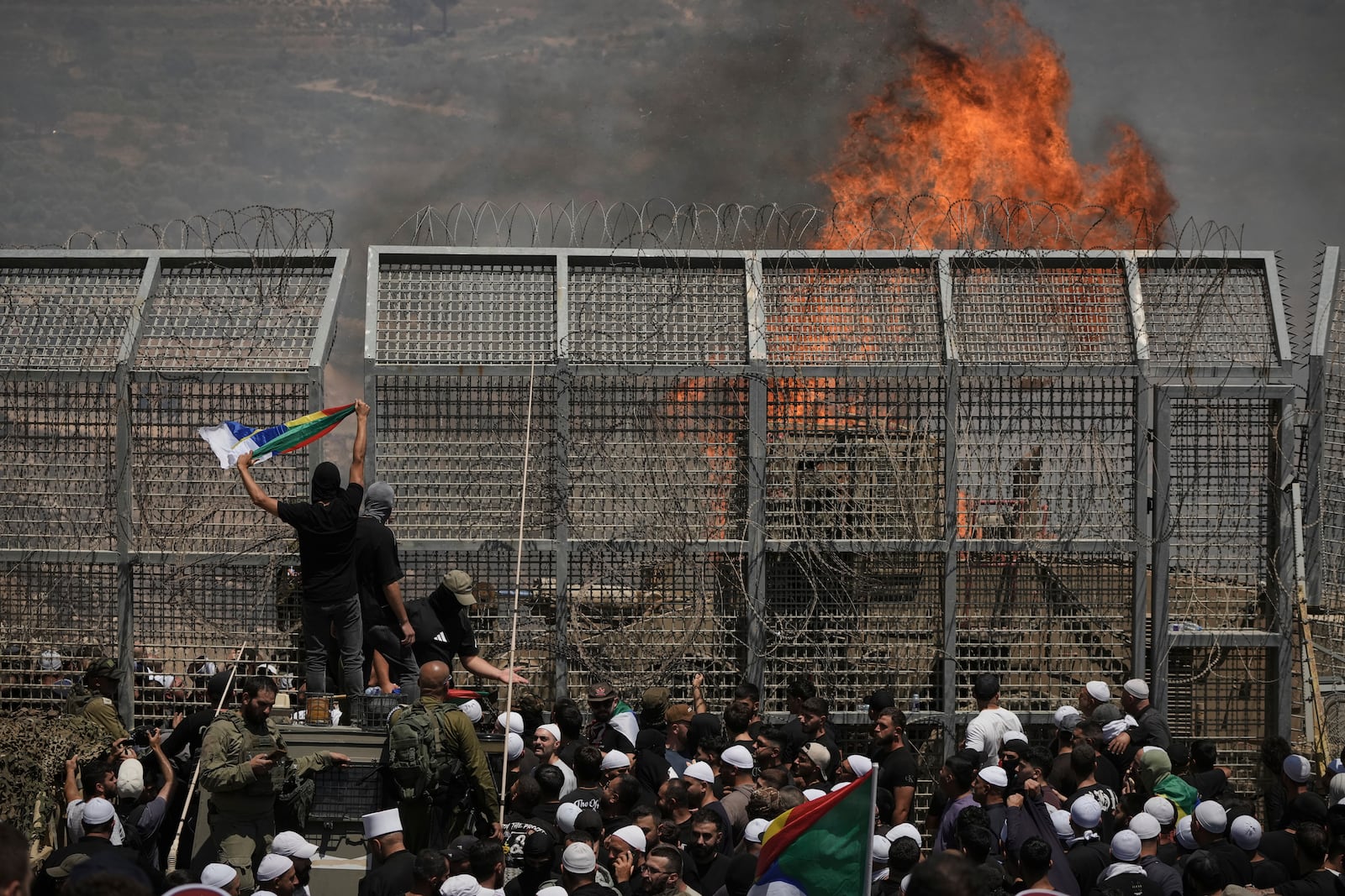 Druze from Syria and Israel protest on the Israeli-Syrian border, in Majdal Shams in the Israeli-controlled Golan Heights, Wednesday, July 16, 2025, amid the ongoing clashes between Syrian government forces and Druze armed groups in the southern Syrian city of Sweida. (AP Photo/Leo Correa)