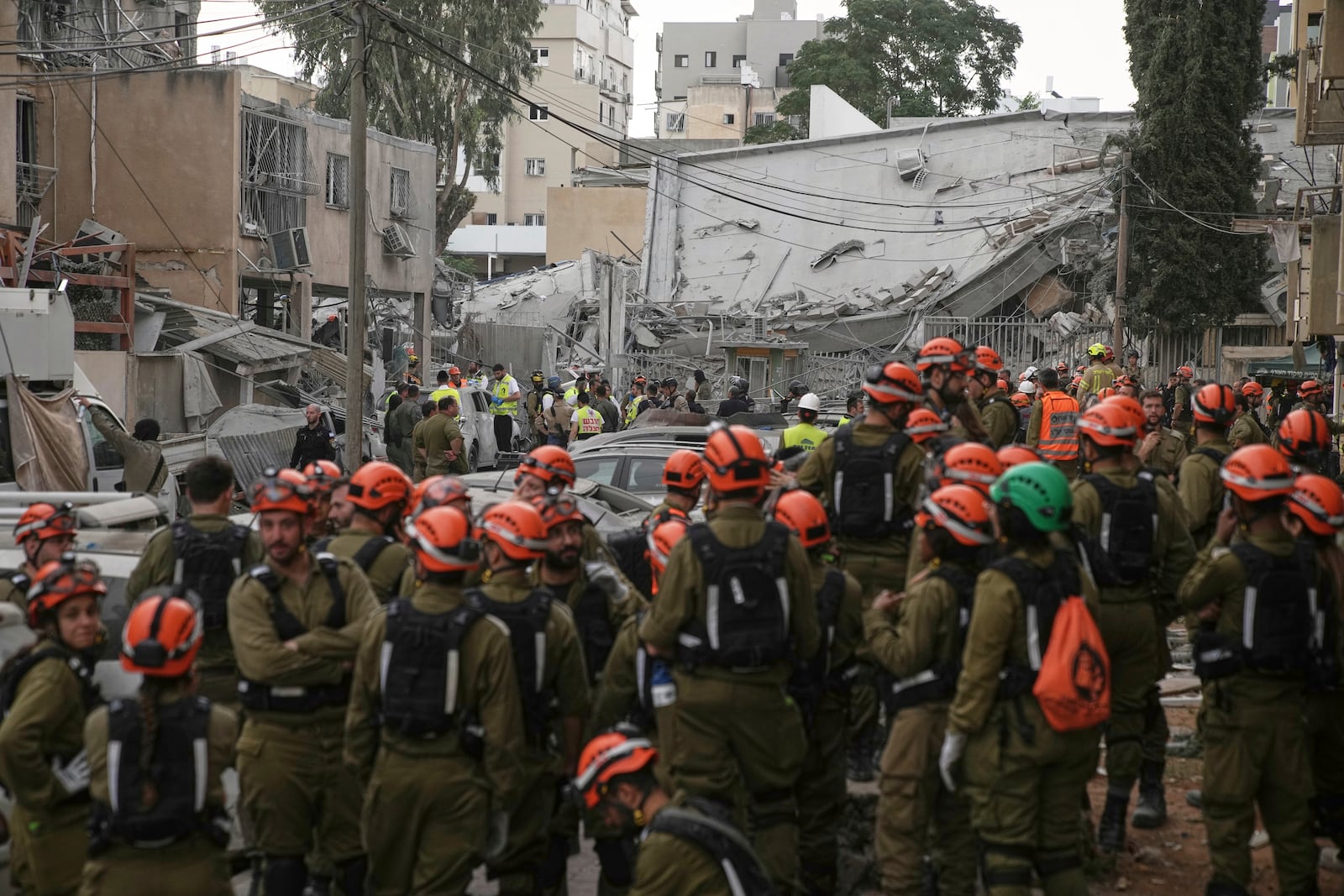 Rescue workers, police and military inspect the site where an Iranian missile struck in Bnei Brak, near Tel Aviv, Israel, Monday, June 16, 2025. (AP Photo/Leo Correa)