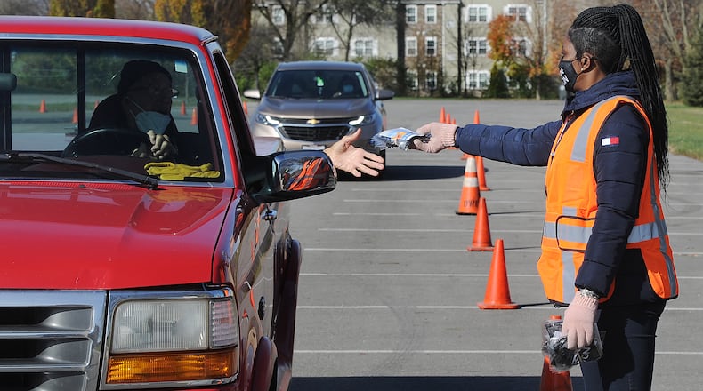 Michelle Buford, a facilities specialist for the city of Dayton, helped to pass out masks Wednesday near Kettering Fields. The mask are free of charge. MARSHALL GORBY\STAFF