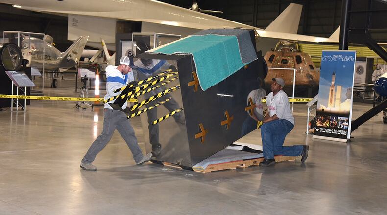 Exhibit specialists Taylor Burkhardt (left) and Quinton Johnson install the Global Positioning System exhibit in the Space Gallery at the National Museum of the U.S. Air Force. (U.S. Air Force photo/Ken LaRock)