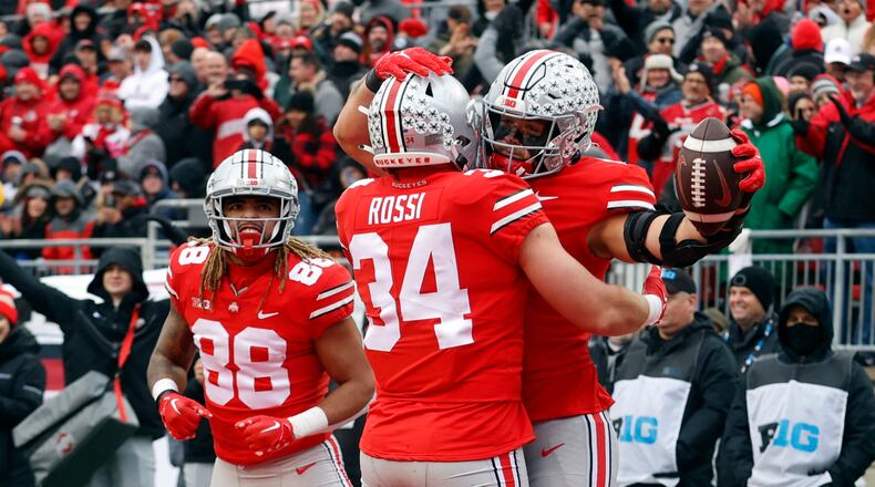 Ohio State tight end Cade Stover, right, celebrates one of his touchdowns against Indiana with teammate tight end Mitch Rossi, center, and tight end Gee Scott during the second half of an NCAA college football game Saturday, Nov. 12, 2022 in Columbus, Ohio. Ohio State won 56-14. (AP Photo/Paul Vernon)