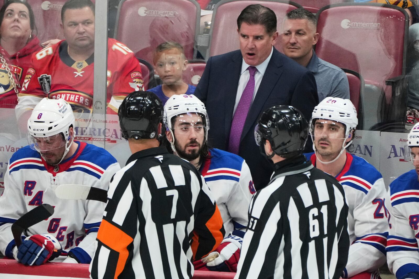 New York Rangers head coach Peter Laviolette, center, rear, talks with officials during the third period of an NHL hockey game against the Florida Panthers, Monday, April 14, 2025, in Sunrise, Fla. (AP Photo/Lynne Sladky)