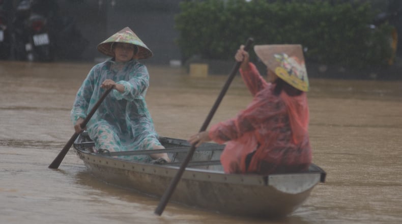 People paddle a boat on a flooded street in Hue, Vietnam, Tuesday, Oct. 28, 2025. (Van Dung/VNA via AP)