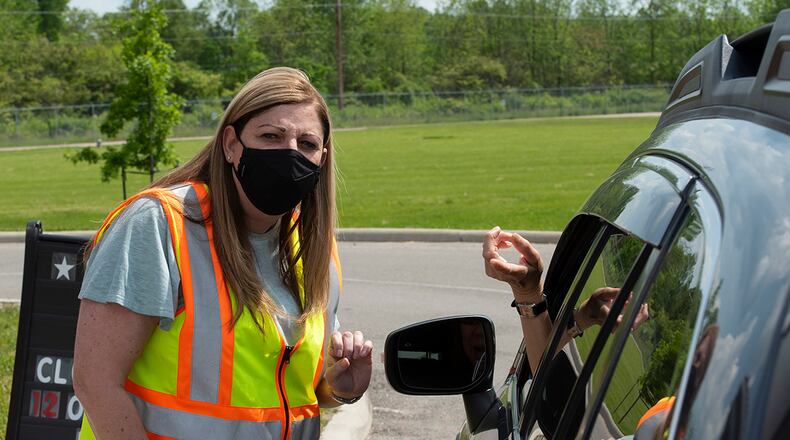 Beth Miller helps a customer in the drive-thru line May 19 at Kittyhawk Pharmacy on Wright-Patterson Air Force Base. She is the wife of Col. Patrick Miller, 88th Air Base Wing and installation commander. The base’s key spouses volunteered to help out as the pharmacy’s lobby remains closed due to the COVID-19 pandemic. Key spouses provide communication and support between a unit’s chain of command and Airmen’s family members. U.S. AIR FORCE PHOTO/R.J. ORIEZ