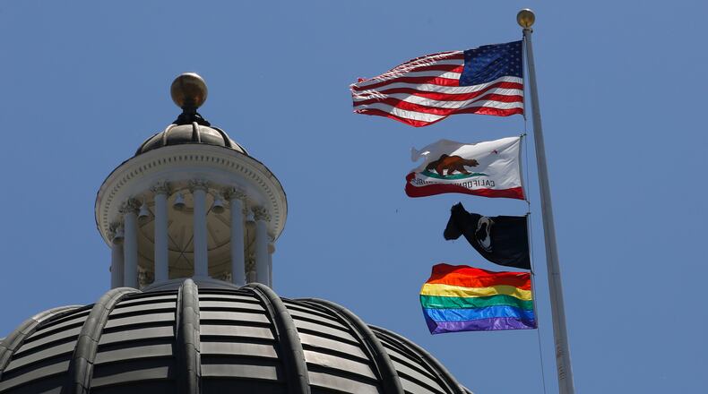The rainbow Pride flag flutters from the flag pole at the state Capitol in Sacramento, Calif., Monday, June 17, 2019. California's governor has signed a law he says will help military service members who were discharged under "don't ask, don't tell" policies to reestablish eligibility for Veterans Affairs benefits. Gov. Gavin Newsom said Saturday, Sept. 17, 2022, many veterans who were discharged because of sexual or gender identities don't know how to access benefits they might be eligible for. The law requires the state to create a grant program to help LGBTQ veterans through the process. (AP Photo/Rich Pedroncelli, File)