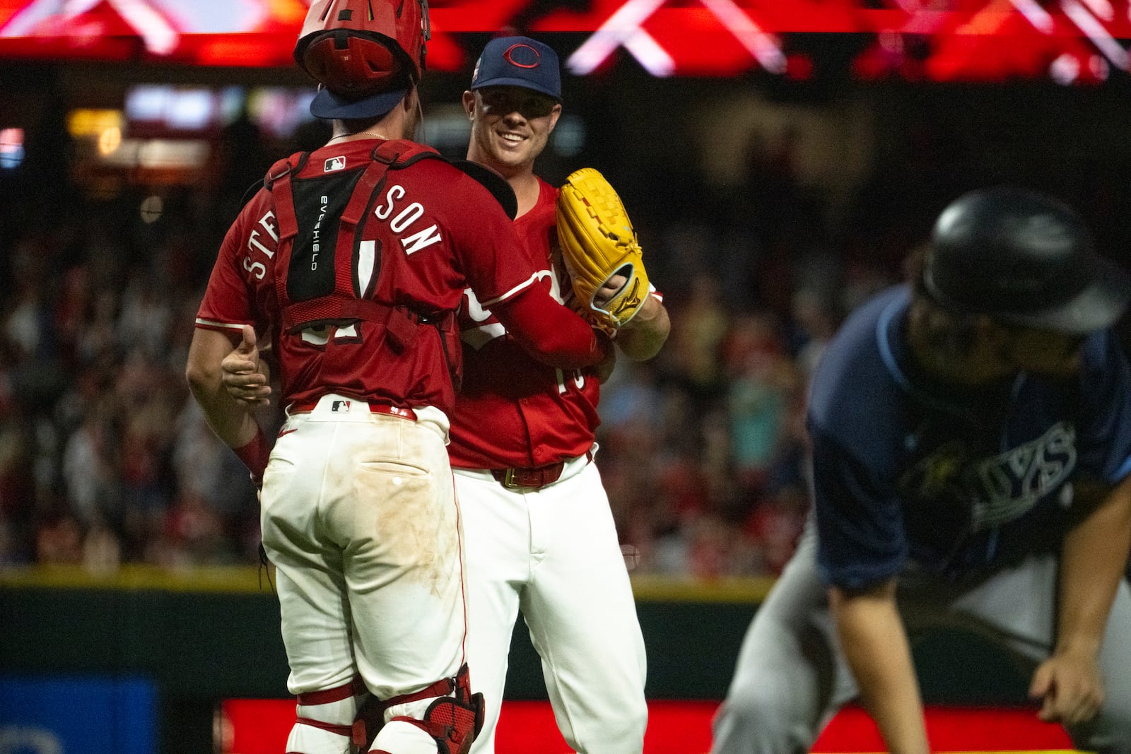 Cincinnati Reds catcher Tyler Stephenson, left, and pitcher Emilio Pagán, second from left, celebrate after defeating the Tampa Bay Rays in a baseball game, Saturday, July 26, 2025, in Cincinnati. (AP Photo/Michael Swensen)