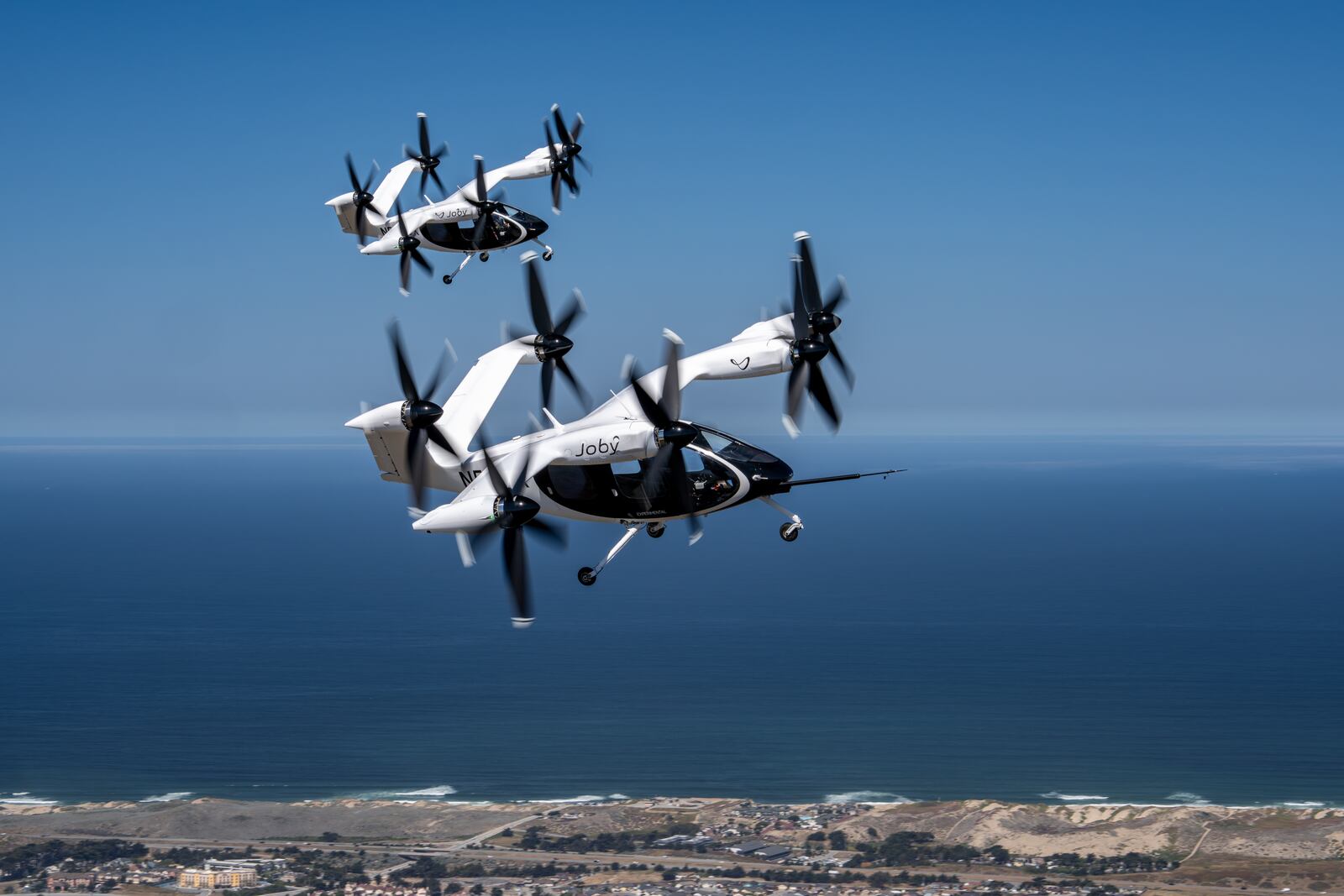 Two Joby air taxis (N541JX and N544JX) flying simultaneously in the skies over Marina, CA. Joby Aviation photo