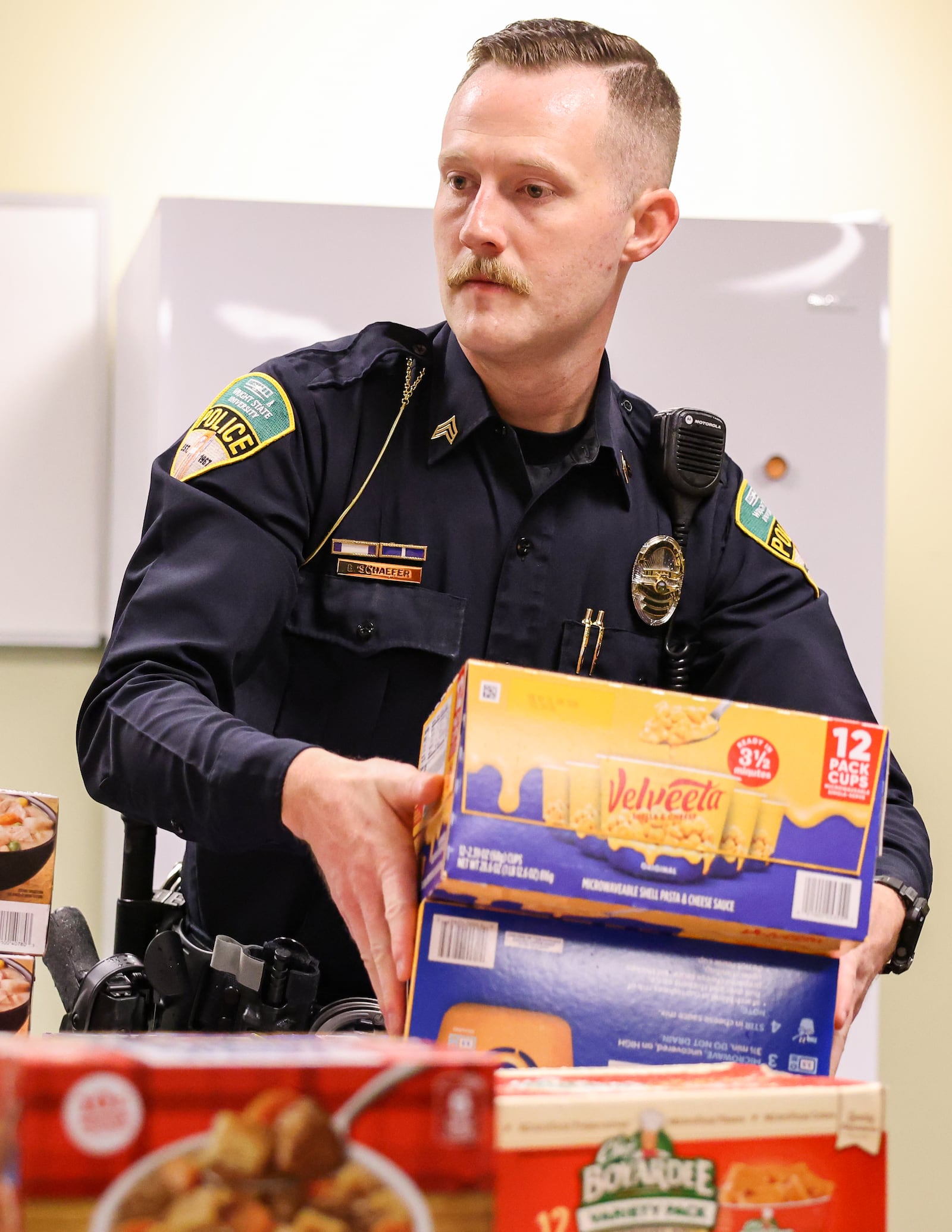 Wright State police sergeant Ben Schaefer unloads boxes of food in the Raider Food Pantry at the university's Student Union on Tuesday, Nov. 25. It's the seventh year the police department has held a "No Shave November," fundraiser for the food pantry. BRYANT BILLING/STAFF