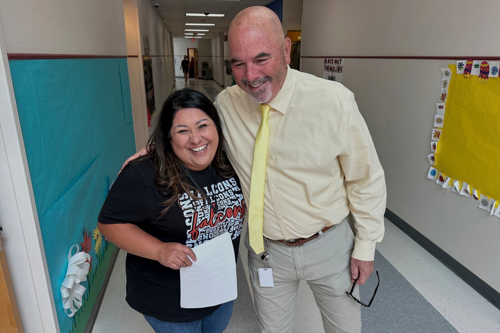 Superintendent Lee White shares a hug with teacher Vanessa Calderon in the hall of the elementary school in Loving, N.M., on Monday, May 19, 2025. (AP Photo/Susan Montoya Bryan)