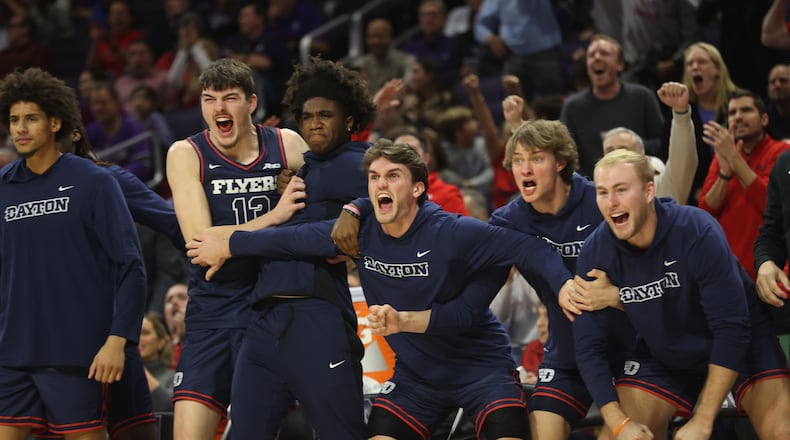 Dayton players on the bench react to a dunk by DaRon Holmes II against Northwestern on Friday, Nov. 10, 2023, at Welsh-Ryan Arena in Evanston, Ill. David Jablonski/Staff