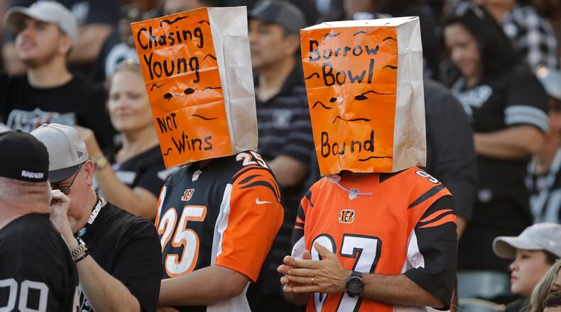 Cincinnati Bengals fans wear paper bags on their heads during the second half of an NFL football game against the Oakland Raiders in Oakland, Calif., Sunday, Nov. 17, 2019. (AP Photo/Ben Margot)