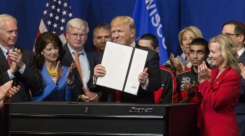 President Donald Trump signs the so-called “Buy American, Hire American” executive order on April 18, 2017, during a visit to Snap-on Inc. in Kenosha, Wis. The orders clamp down on guest worker visas and require federal agencies to buy more goods and services from U.S. companies and workers. (Mark Hoffman/Milwaukee Journal Sentinel/TNS)