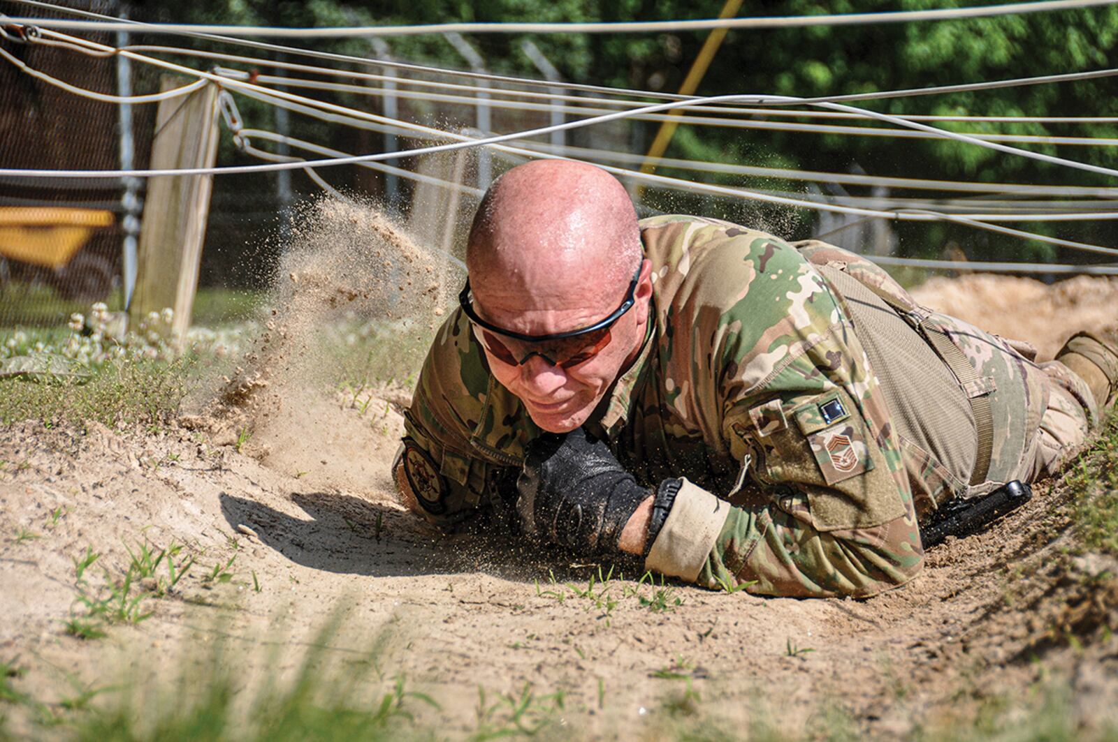 Chief Master Sgt. James Kirklin, 445th Security Forces Squadron, low-crawls through a sand pit under suspended wire during a nine-part obstacle course June 8 at Camp Dawson, West Virginia. The 445 SFS senior enlisted leader joined a four-person fire team to participate in the training event. U.S. AIR FORCE PHOTO/CAPT. RACHEL INGRAM