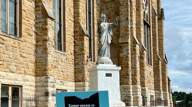 A sign near St. Raphael Church in Springfield with the Haitian Creole phrase that translates to, "Love your neighbor, protect your stranger." AIMEE HANCOCK/STAFF