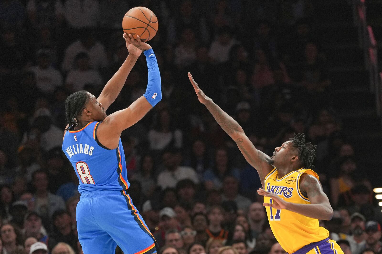 Oklahoma City Thunder forward Jalen Williams, left, shoots over Los Angeles Lakers forward Dorian Finney-Smith, right, during the first half of an NBA basketball game, Tuesday, April 8, 2025, in Oklahoma City. (AP Photo/Kyle Phillips)