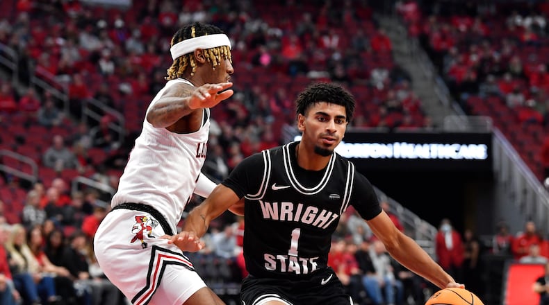 Wright State guard Trey Calvin (1) attempts to drive past Louisville guard El Ellis (3) during the first half of an NCAA college basketball game in Louisville, Ky., Saturday, Nov. 12, 2022. (AP Photo/Timothy D. Easley)