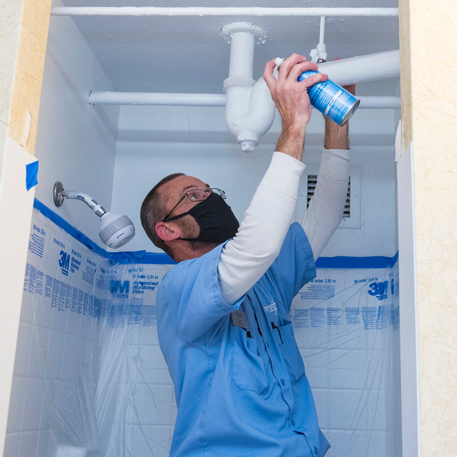 Ron Bertke, a Wright-Patterson Inns maintenance worker, sprays waterproof sealant in a guestroom shower on Nov. 5. U.S. AIR FORCE PHOTO/JAIMA FOGG