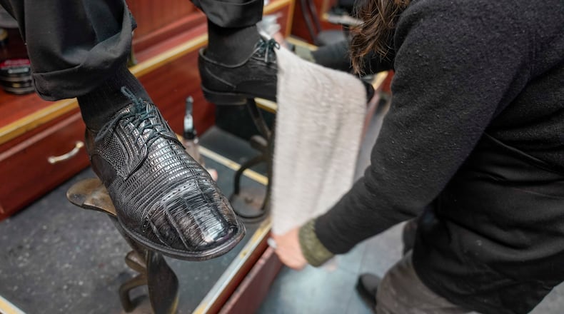 Bertha Gomez shines a customer's shoes at the Alpha Shoe Repair Corp., Friday, Feb. 3, 2023, in New York. Once a common practice, the tradition of getting a quick polish from a rag-toting shoeshine has become more of a rarity, and many stands have disappeared across the country. (AP Photo/Mary Altaffer)