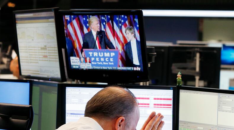 A broker reacts as new elected U.S. President Donald Trump shows up on a television screen at the stock market in Frankfurt, Germany, Wednesday. (AP Photo/Michael Probst)