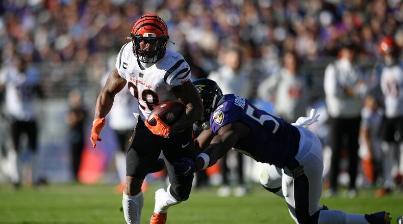 Cincinnati Bengals running back Joe Mixon, left, gets by the tackle attempt of Baltimore Ravens outside linebacker Justin Houston before scoring a touchdown during the second half of an NFL football game, Sunday, Oct. 24, 2021, in Baltimore. (AP Photo/Nick Wass)
