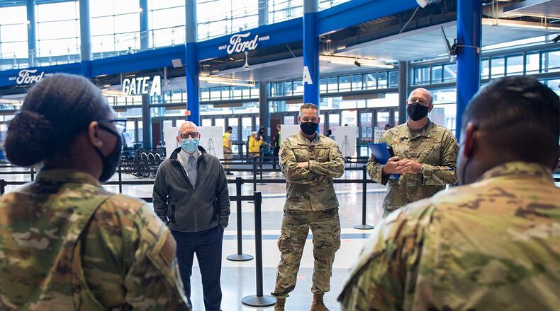 From left: Gregory Leingang, 88th Air Base Wing vice director; Col. Christian Lyons, 88th Medical Group commander; and Col. Patrick Miller, 88 ABW and installation commander, talk with 88th Medical Group Airmen from Wright-Patterson Air Force Base who are working in the community vaccination center’s registration area on May 3 at Ford Field in Detroit. U.S. AIR FORCE PHOTO/WESLEY FARNSWORTH