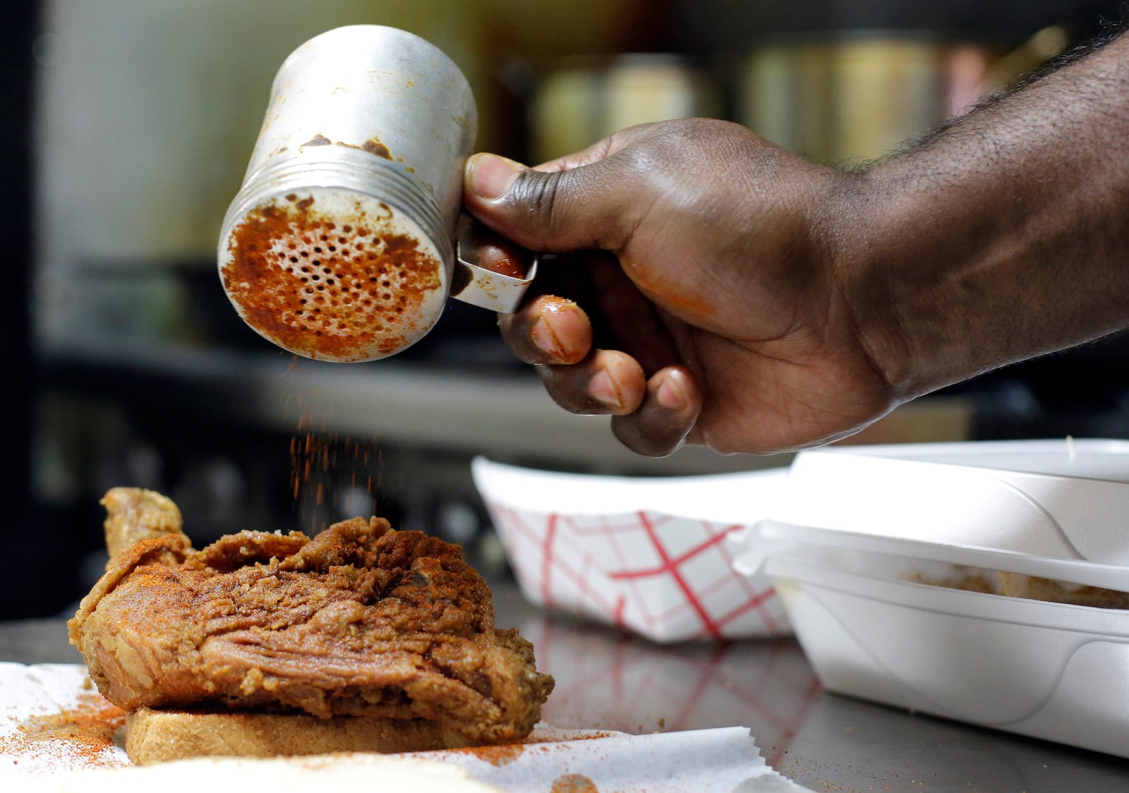 FILE - Keith Graham sprinkles hot seasoning on an order of chicken at Bolton's Spicy Chicken and Fish restaurant in Nashville, Tenn. on Friday, March 22, 2013. (AP Photo/Mark Humphrey,File)