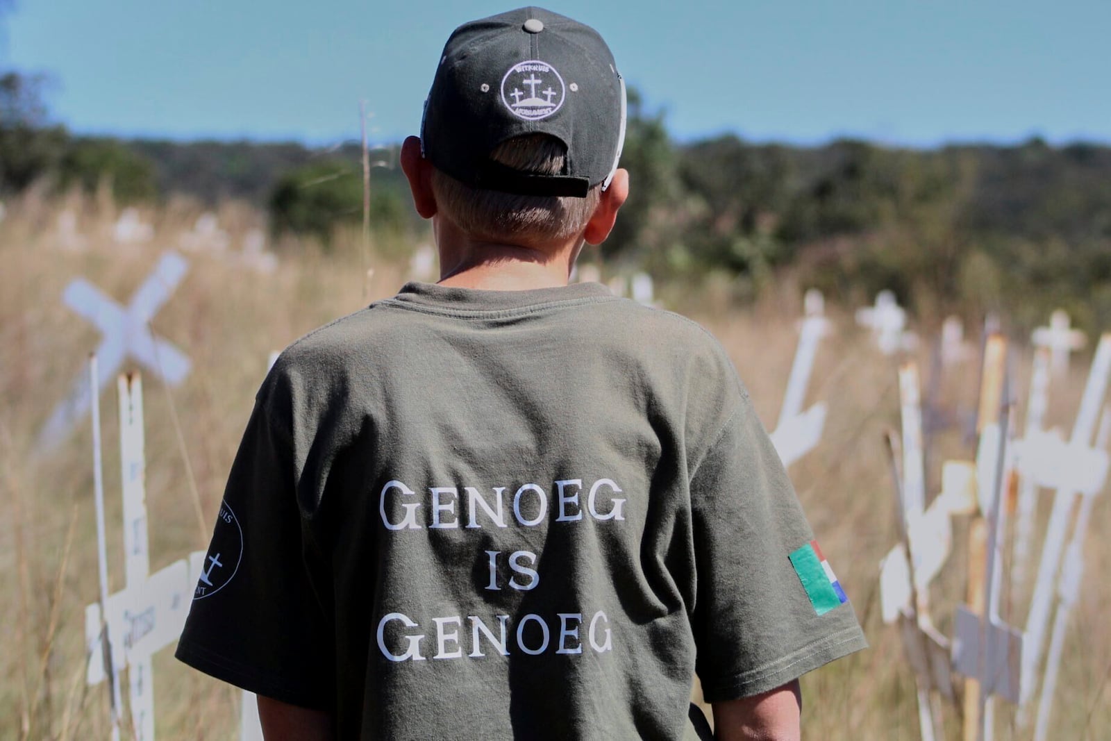 Jano de Lange, wearing a shirt that reads, "Enough is enough," observes white crosses at the Witkruis Monument, near Polokwane, South Africa, May 24, 2025. (AP Photo/Mogomotsi Magome)