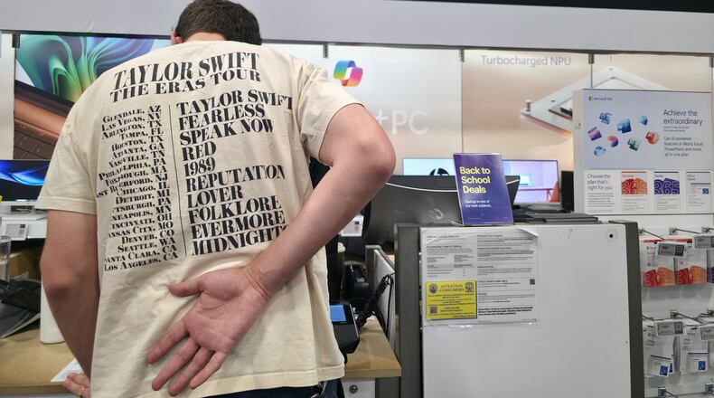 FILE - Middle school teacher Jeremy Hook shops for the latests Microsoft's Surface Laptop Copilot+ PC's at Best Buy Atwater Village store in Glendale, Calif., Tuesday, July 29, 2025. (AP Photo/Damian Dovarganes, File)