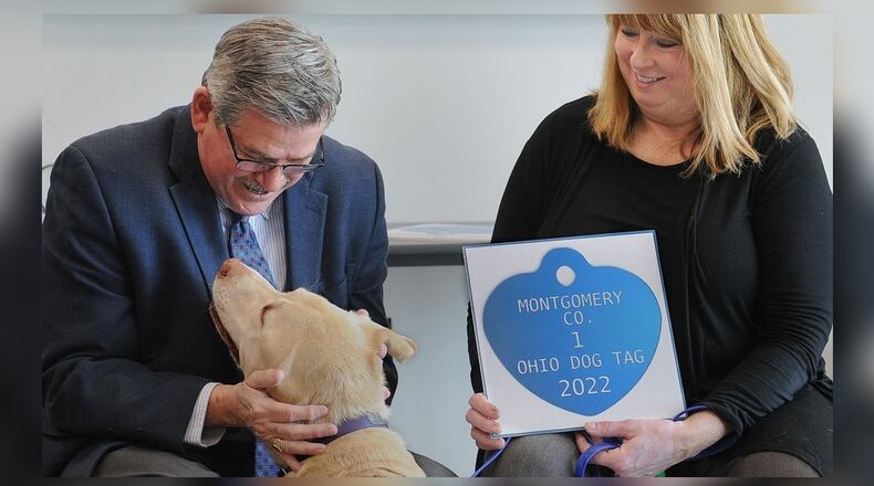 Montgomery County Auditor Karl Keith, left, congratulates Manchu and his owner Elaine Allison for receiving the Montgomery County 1 Ohio Dog Tag for 2022. The ceremony held Wednesday, Jan. 19, 2022, at the SICSA Pet Adoption and Wellness Center in Washington Twp. recognizes the top three dogs of the year in the county. MARSHALL GORBY\STAFF
