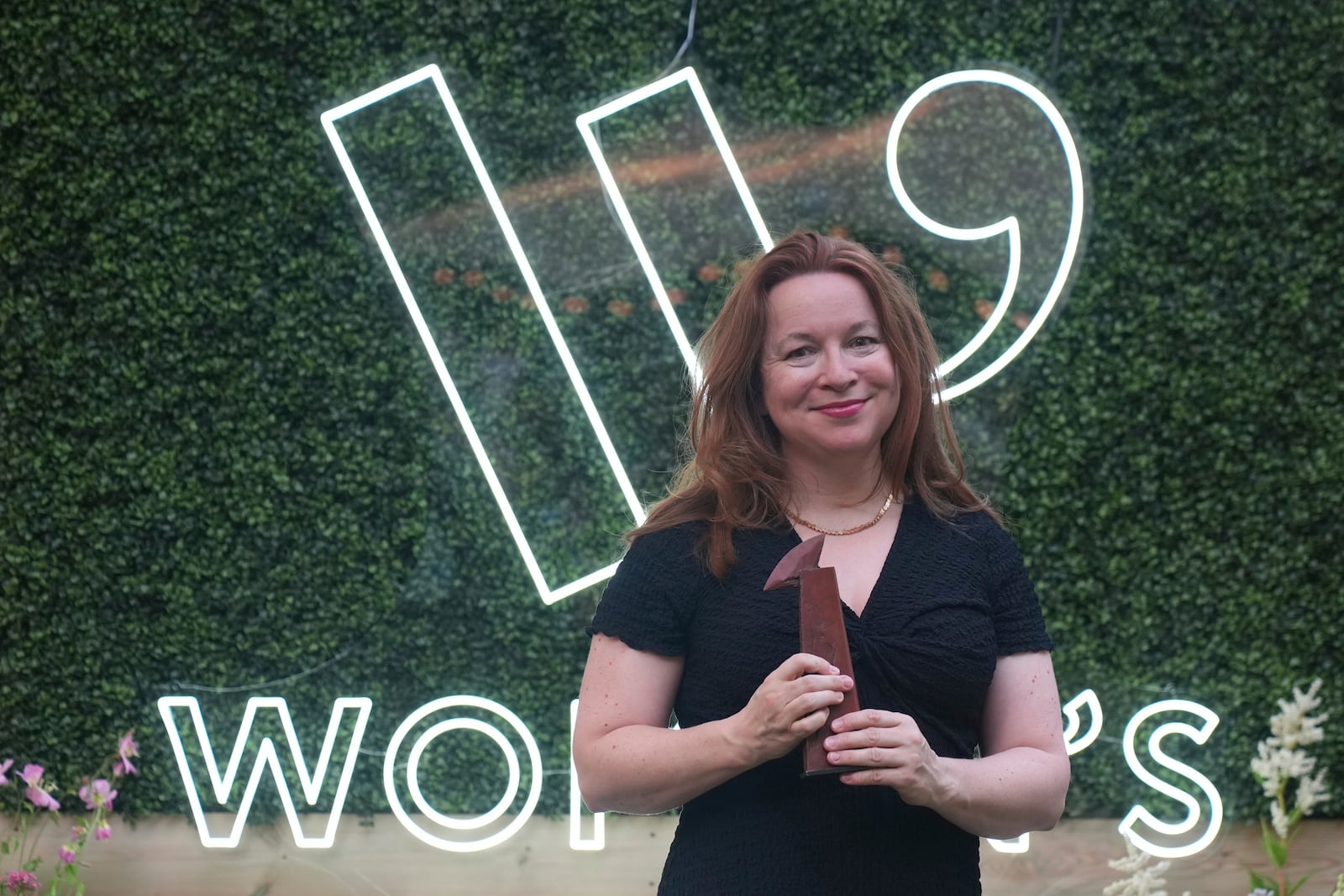 Winner of the Women's Prize for Fiction Rachel Clarke for her book 'The Story of a Heart' holds her trophy as she poses for the media in London, Thursday, June 12, 2025. (AP Photo/Joanna Chan)