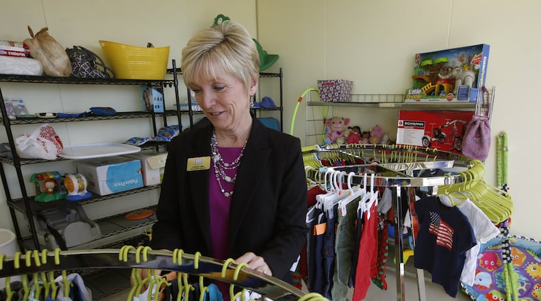 Sherry Ems, executive director, USO Central and Southern Ohio, sorts through donated children’s clothes in the Airman’s Attic of the new USO at Wright-Patterson Air Force Base. TY GREENLEES / STAFF
