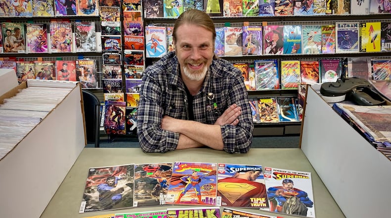 Peter Bell, owner of Bell Book and Comic in Dayton,shows off a selection of Superman and an Incredible Hulk comics. Both superheroes have Ohio connections. LONDON BISHOP/STAFF