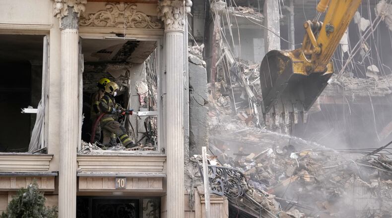 Rescue workers and first responders work at a residential building hit in an earlier U.S.-Israeli strike in Tehran, Iran, Monday, March 23, 2026. (AP Photo/Vahid Salemi)