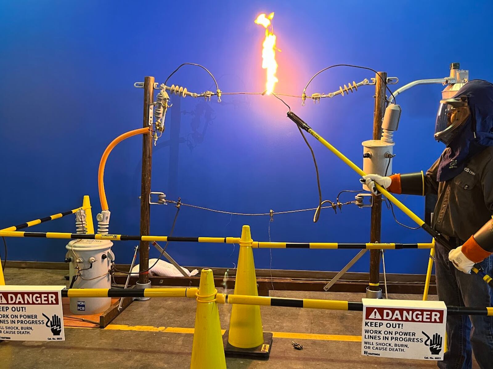 AES Ohio technician A. J. Montgomery touches a live wire with a "hot stick," setting off a flame. THOMAS GNAU/STAFF