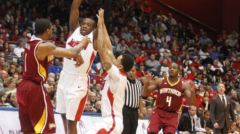 Dayton’s Kendall Pollard, second from left, and Kyle Davis put the pressure on Winthrop’s Brandon Vega on Wednesday, Jan. 1, 2014, at UD Arena. David Jablonski/Staff