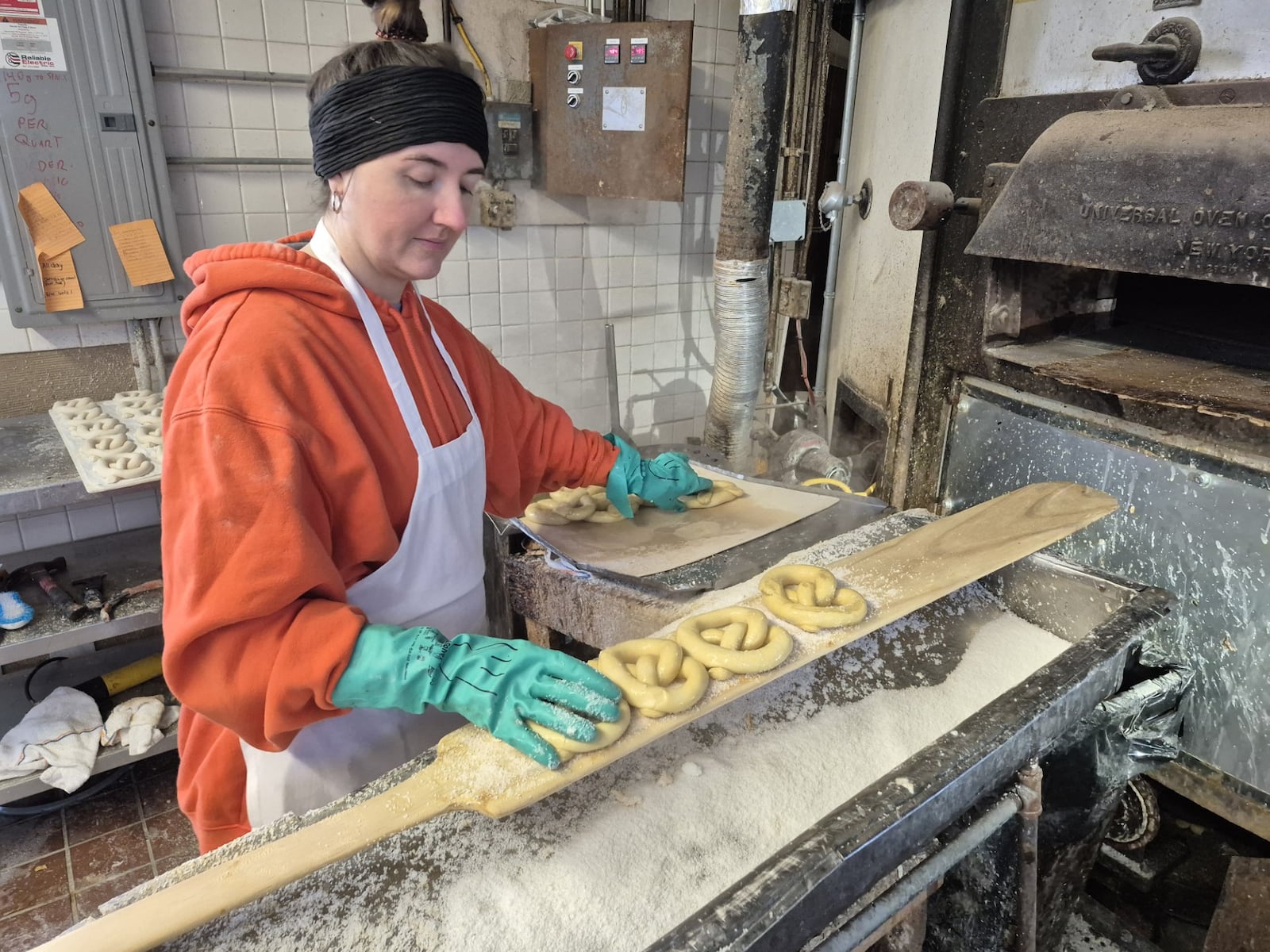 Natalie Hornak salts pretzels at Smales Pretzel Bakery in Dayton. Normally closed on Sunday's, the Xenia Avenue shop pens on Super Bowl Sunday for customers to pick up pre-ordered party platters. MICHAEL KURTZ / STAFF