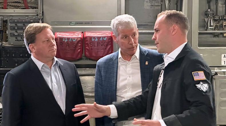 Energy Secretary Chris Wright, center, and Under Secretary of Defense Michael Duffey, left, listen as Isaiah Taylor, CEO of Valar Atomics, discusses a microreactor developed by Valar to generate nuclear power for the military and commercial customers, Sunday, Feb. 15, 2026, in-flight, on board a C-17. (AP Photo/Matthew Daly)