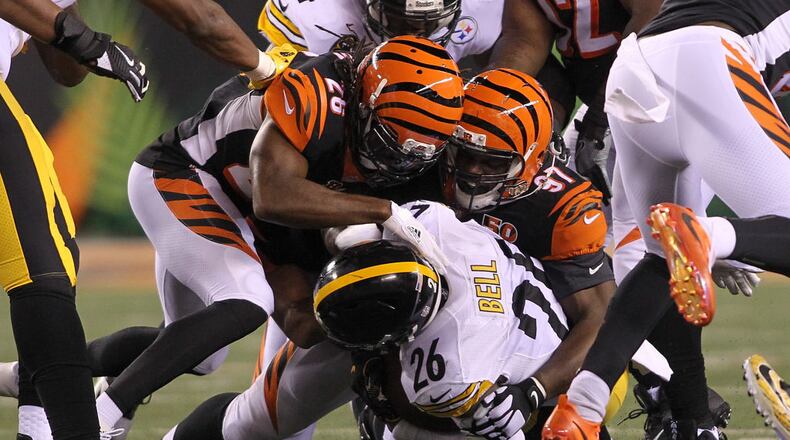 CINCINNATI, OH - DECEMBER 04: Geno Atkins #97 and Josh Shaw #26 of the Cincinnati Bengals tackle Le’Veon Bell #26 of the Pittsburgh Steelers during the first half at Paul Brown Stadium on December 4, 2017 in Cincinnati, Ohio. (Photo by John Grieshop/Getty Images)