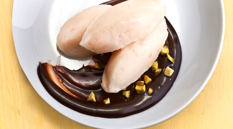 A quenelle, a shape reminiscent of an American football, is an elegant way to serve ice cream. Some ganache finishes the plate. (Bill Hogan/Chicago Tribune/TNS)