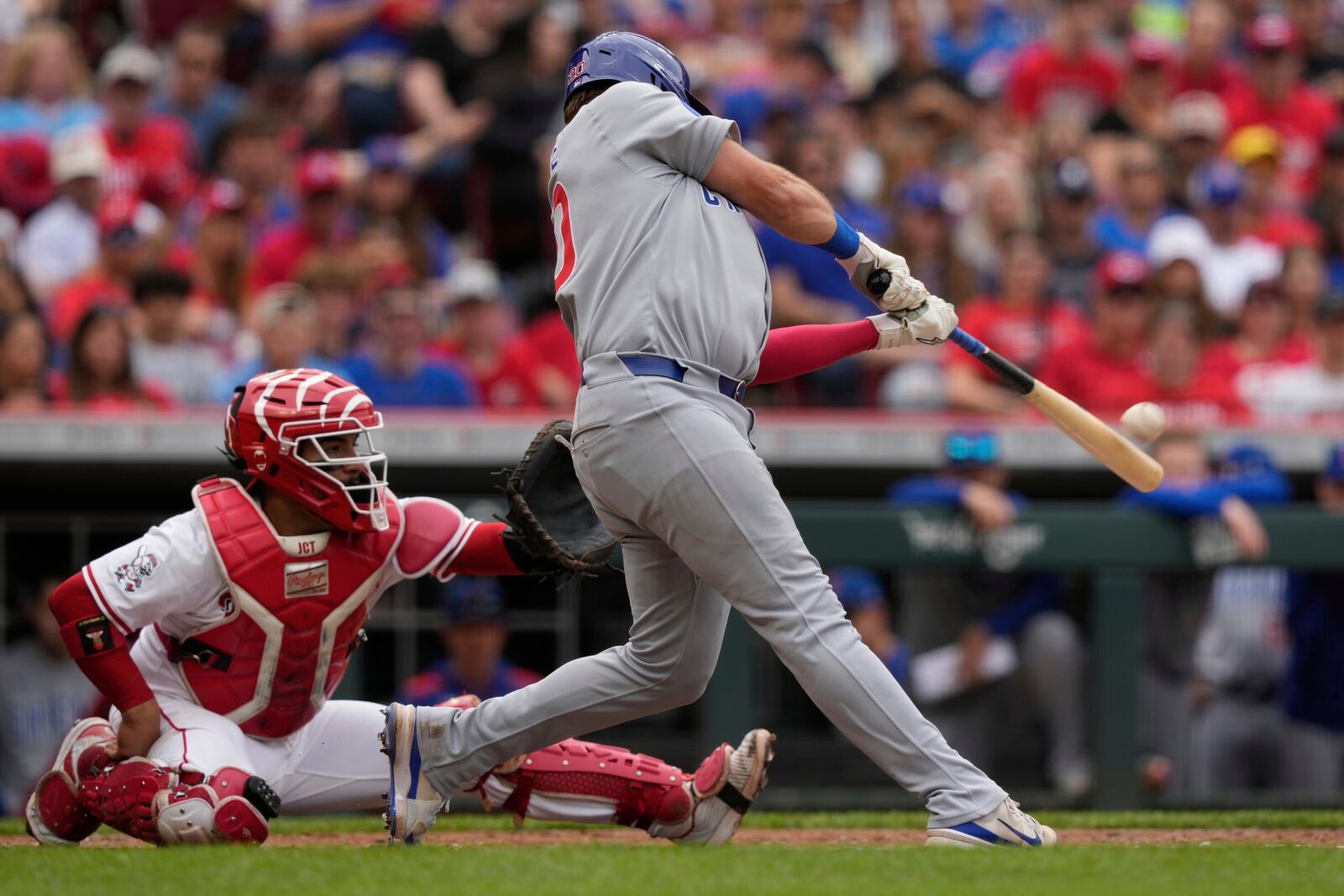 Chicago Cubs' Reese McGuire hits a solo home run as Cincinnati Reds catcher Jose Trevino looks on in the second inning of a baseball game, Sunday, May 25, 2025, in Cincinnati. (AP Photo/Carolyn Kaster)