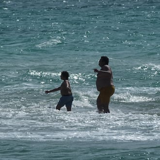 Beachgoers brave the cold ocean temperature while walking on a sandbar Thursday, Jan. 29, 2026, in Miami Beach, Fla. (AP Photo/Marta Lavandier)